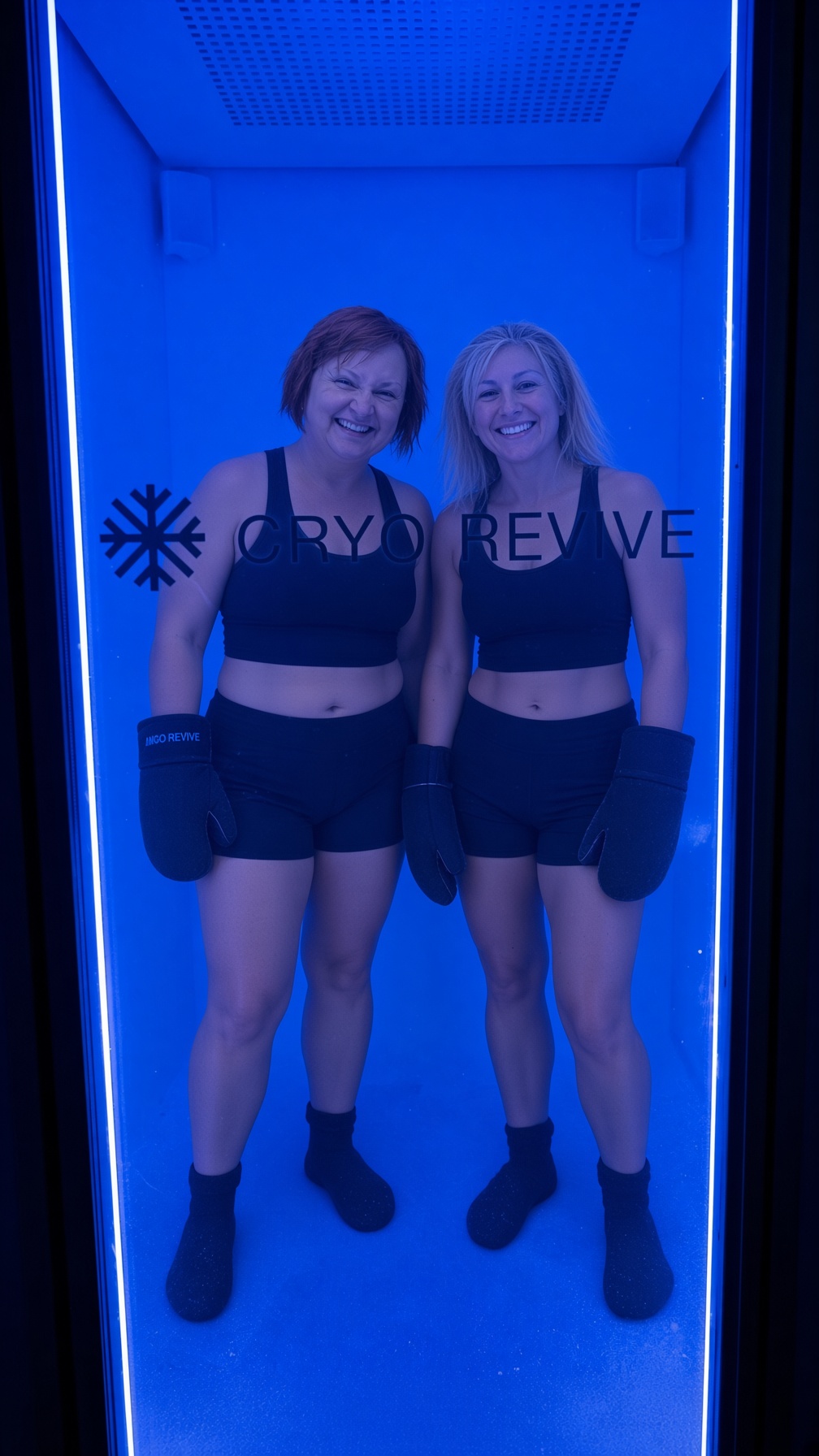 Two women smiling inside the Cryo Revive Mecotec cryotherapy chamber